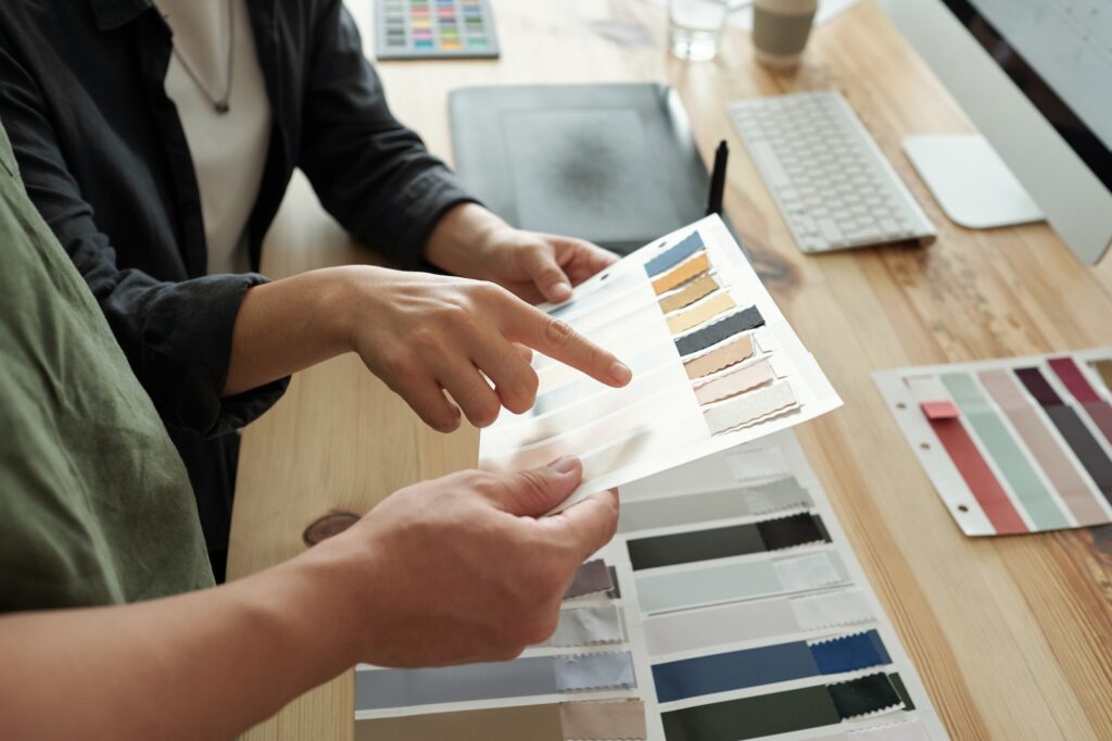 One of two designers pointing at textile sample